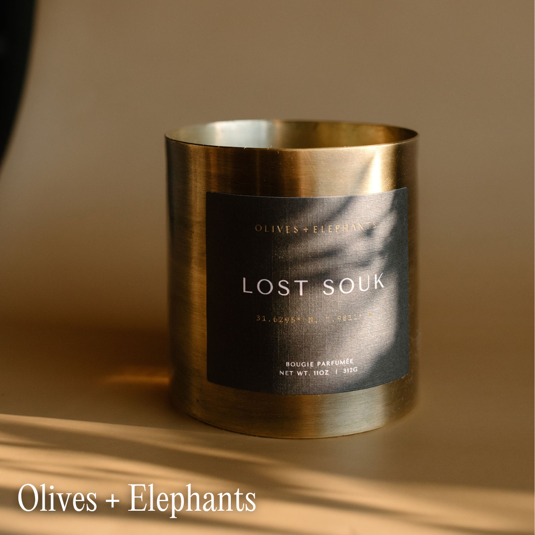 A candle sits on a shadowy surface