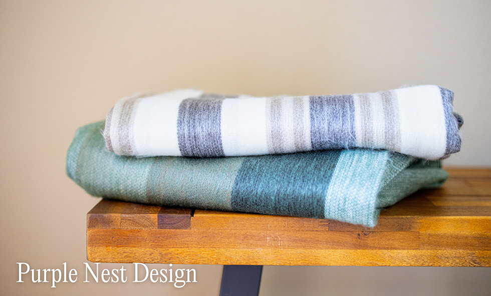 Cozy blankets are folded nicely on a bench